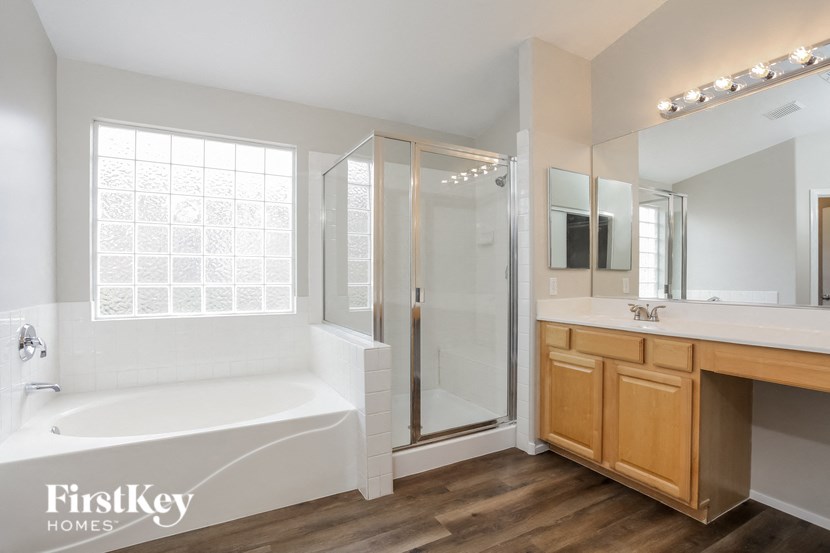 a bathroom with a tub and a shower and a sink