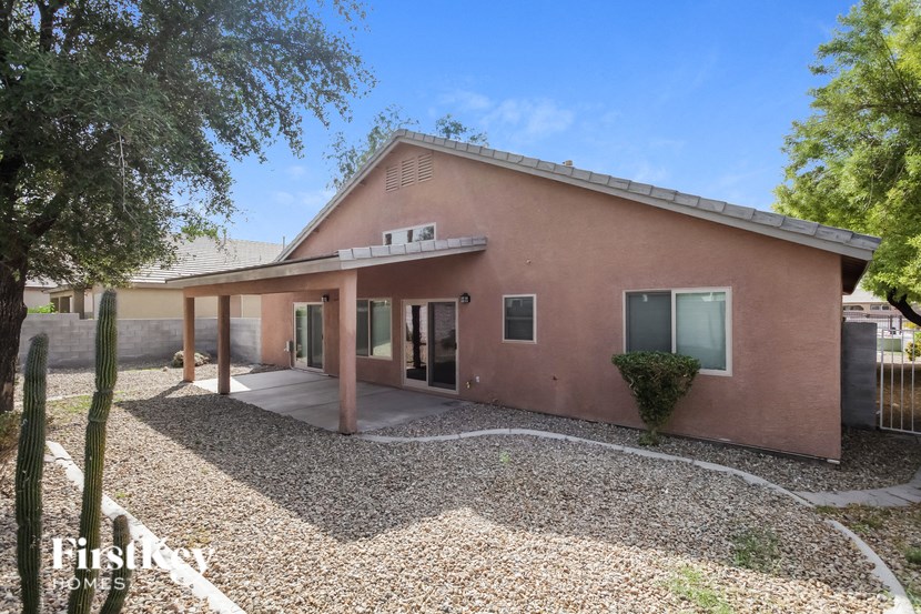 a pink house with a gravel yard and a covered porch