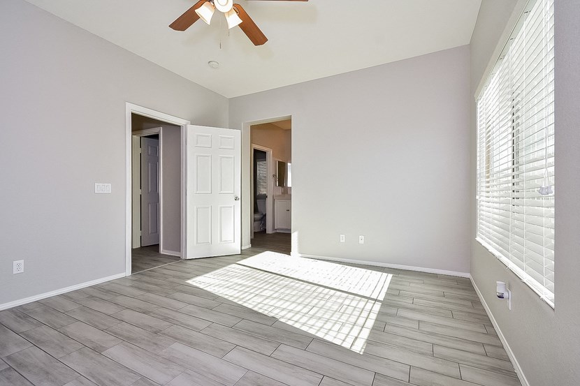 the spacious living room of a new home with a ceiling fan