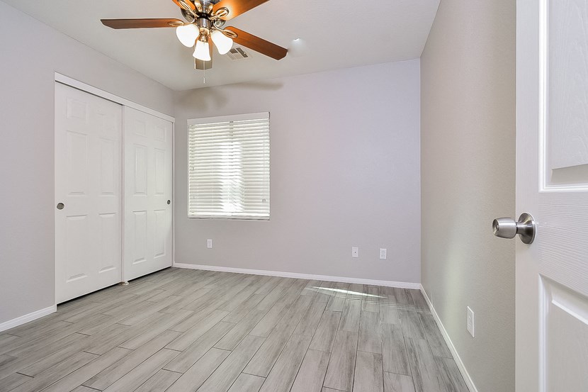 an empty room with a ceiling fan and a door