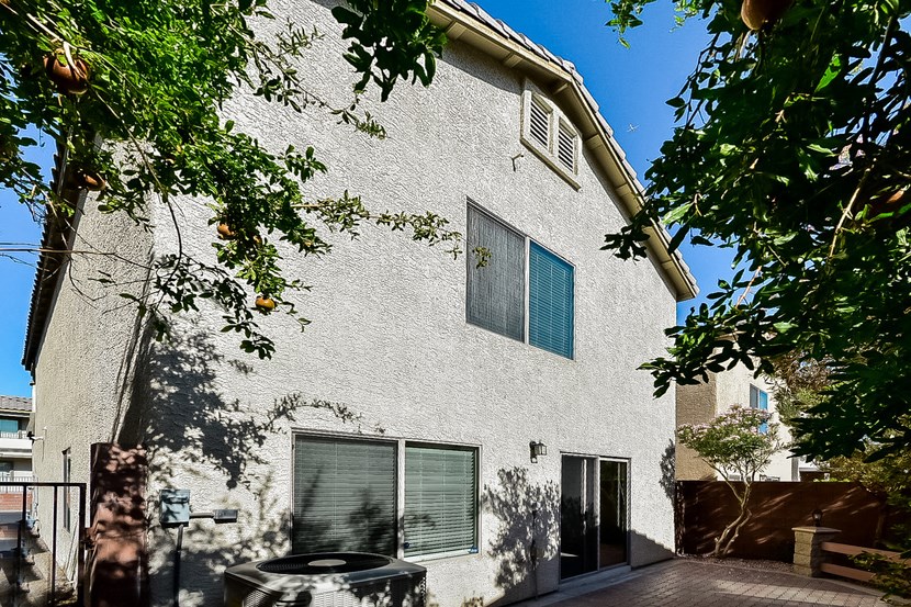 the outside of a white house with trees