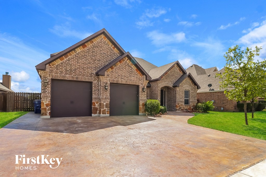 A brick house with a driveway in front of it.