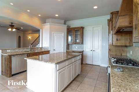 A kitchen with a large island and wooden cabinets.