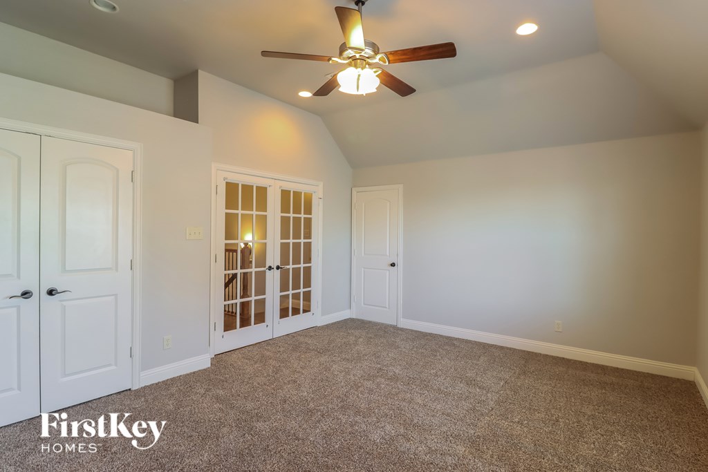 A room with a ceiling fan and a carpeted floor.