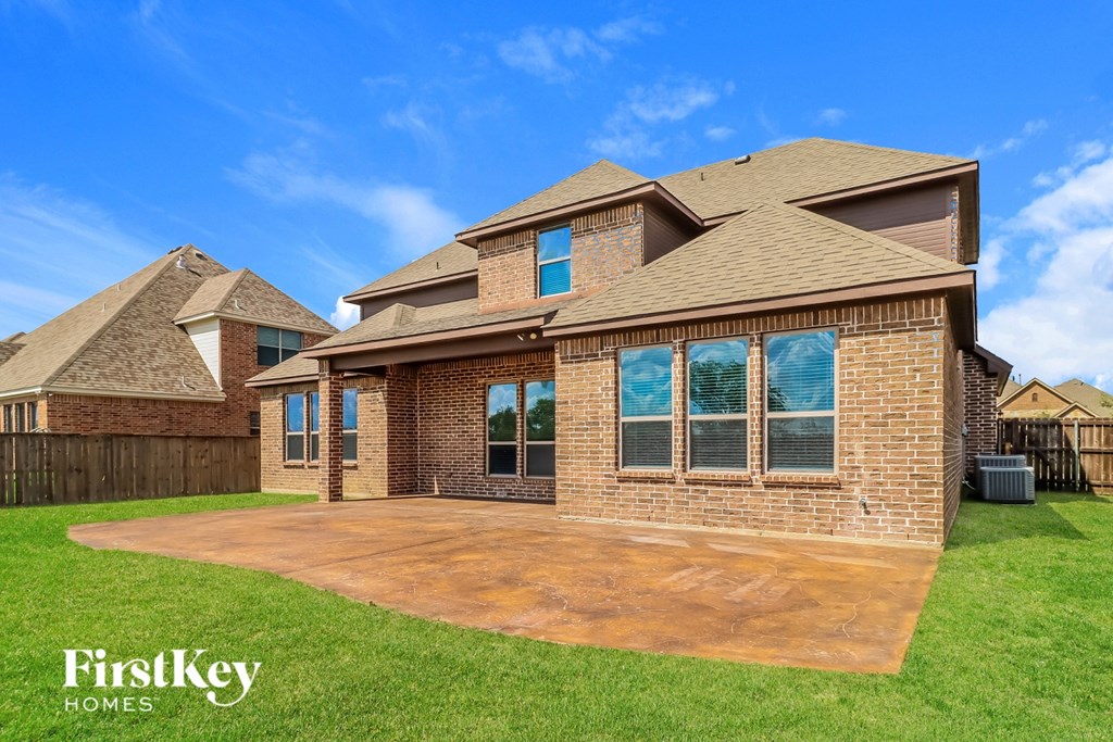 A house with a brown roof and a brick wall is shown.
