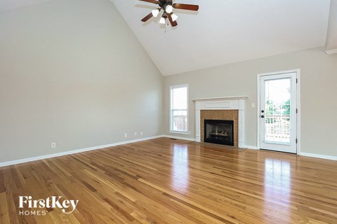 the living room with hardwood floors and a fireplace