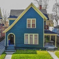 a blue house with a porch on a street