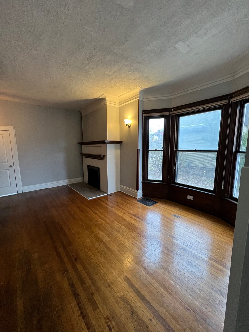 an empty living room with wood floors and large windows