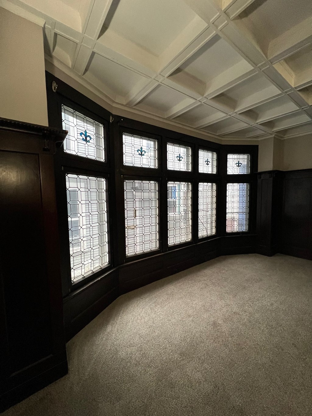 an empty bay window in a room with a carpeted floor