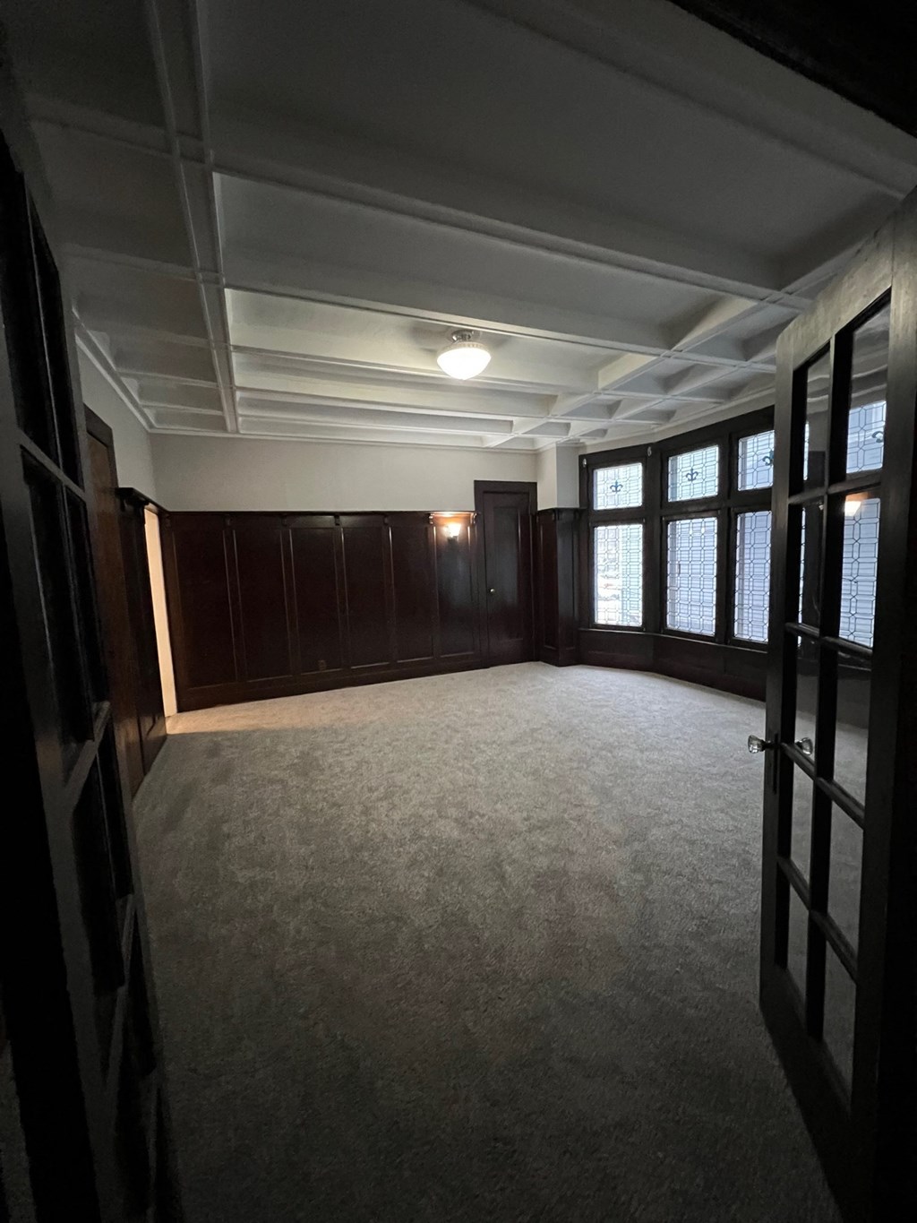 an empty room with wood paneling and a window