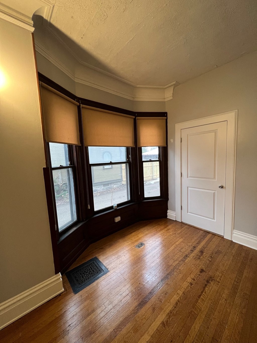 an empty living room with windows and wood floors