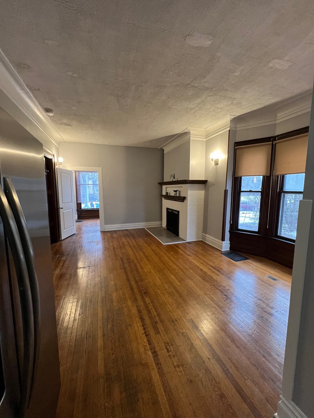 an empty living room with wood floors and a fireplace