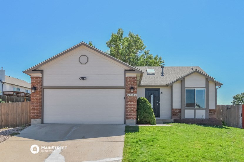 a white house with a driveway and a lawn