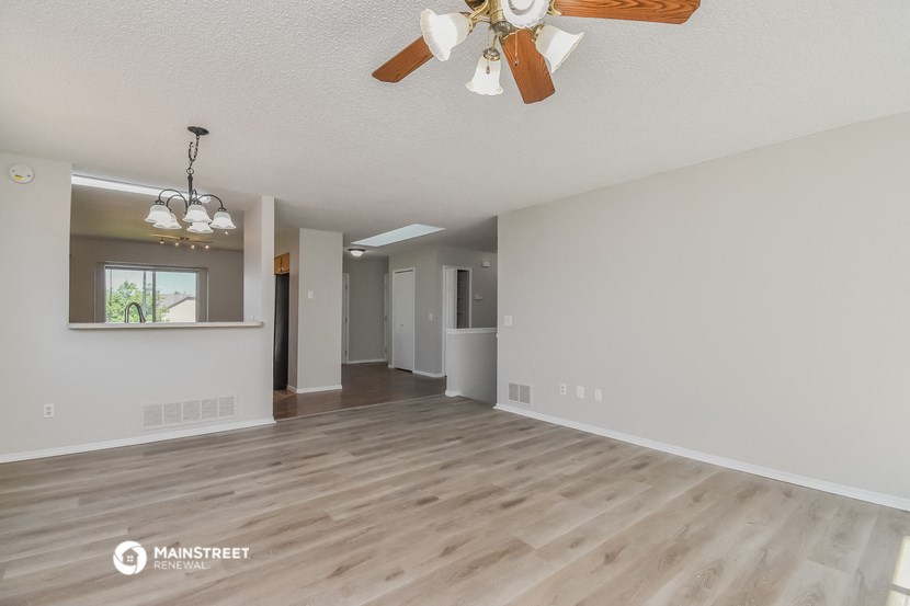 the living room and dining room with a ceiling fan