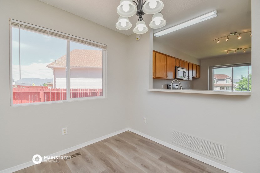 the living room and kitchen of an apartment with a large window