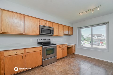 the kitchen with wood cabinets and stainless steel appliances and a large window