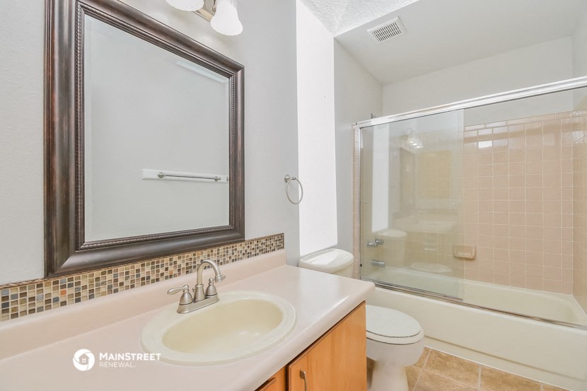 a bathroom with a shower sink and toilet and a mirror