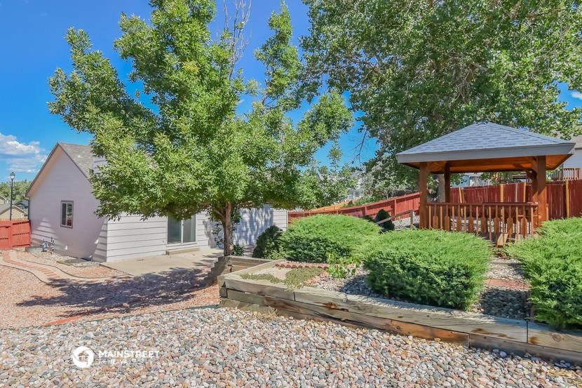 a backyard with a deck and a gazebo