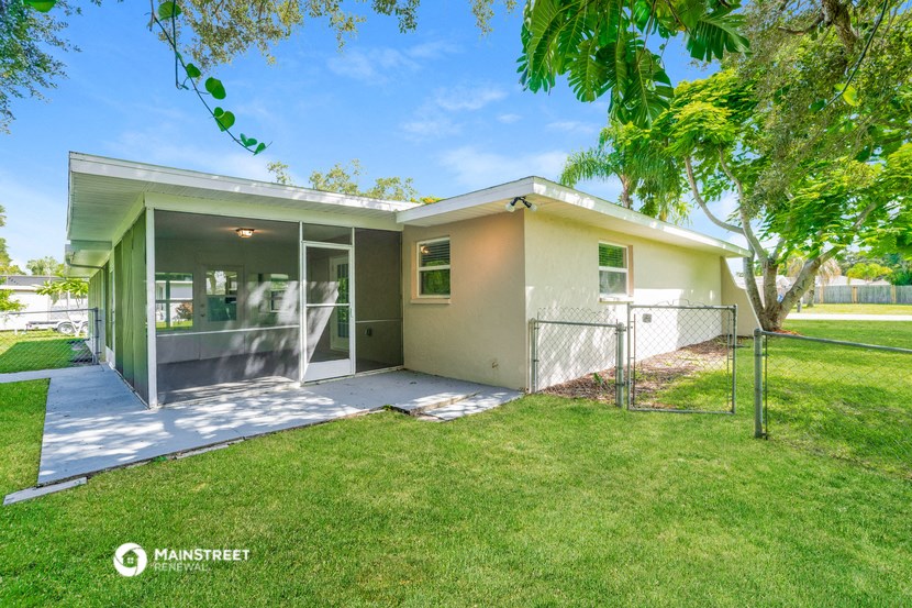 a house with a yard and a chain link fence