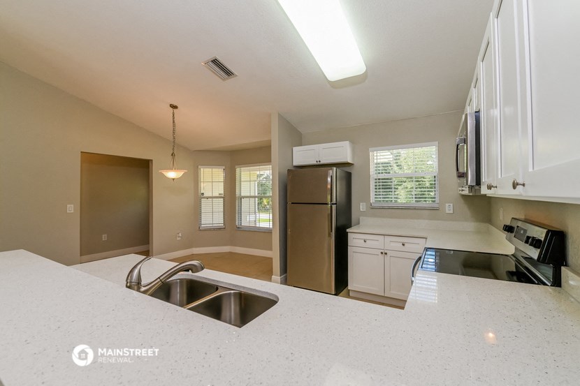 an empty kitchen with stainless steel appliances and white counter tops