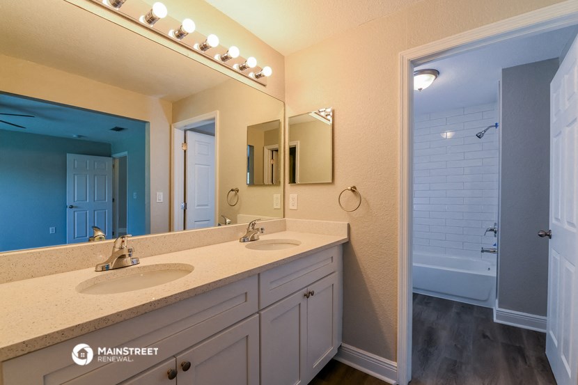 a bathroom with two sinks and a shower and a mirror