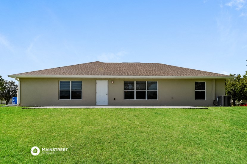 a beige house with a lawn in front of it