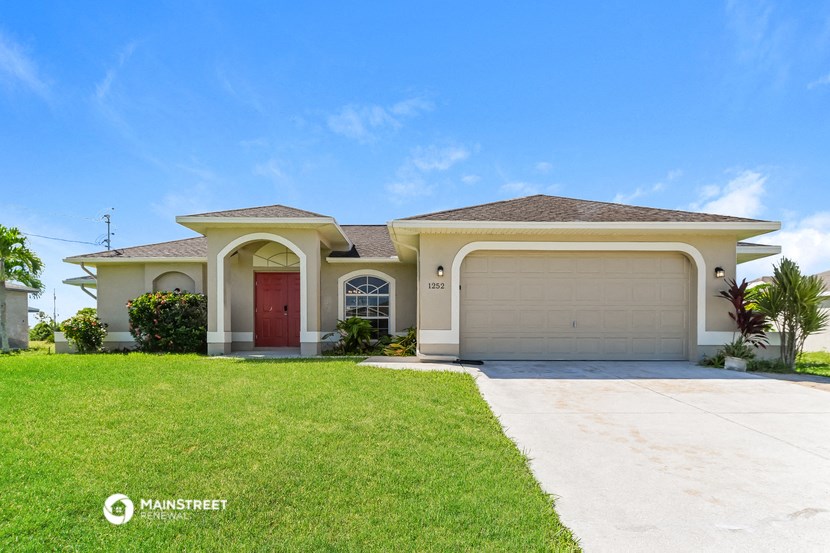 a house with a garage door and a lawn