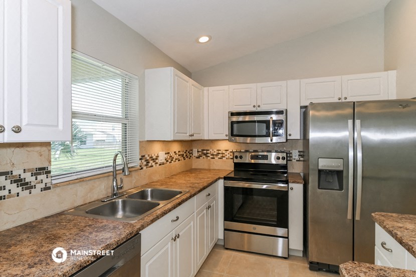 a kitchen with stainless steel appliances and white cabinets