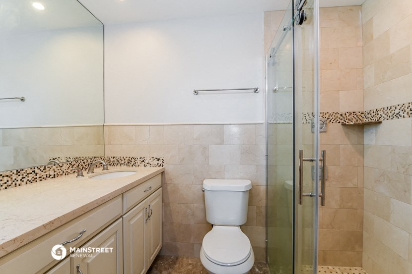 a bathroom with a shower and a sink and a toilet