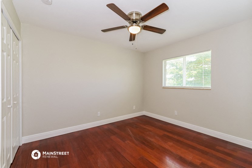 the bedroom with hardwood flooring and a ceiling fan