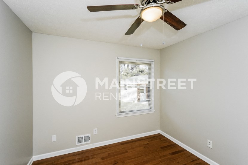a bedroom with a ceiling fan and a window