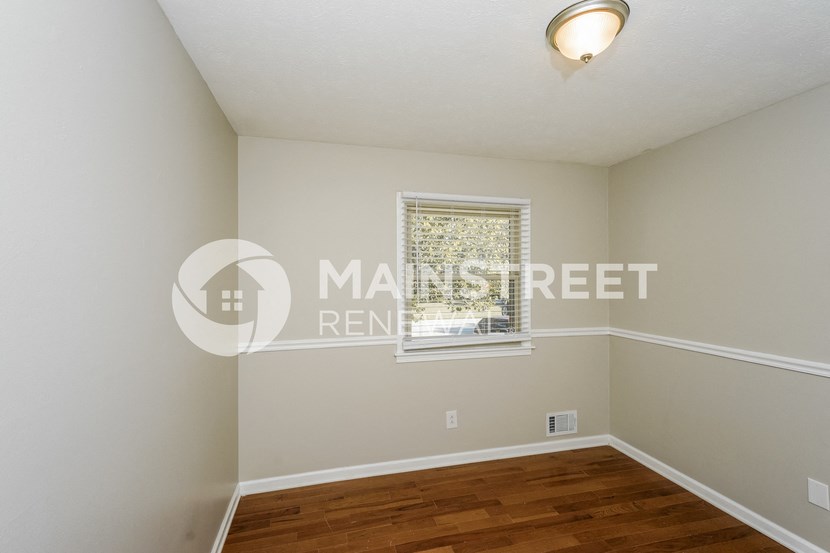 a bedroom with a hard wood floor and a window