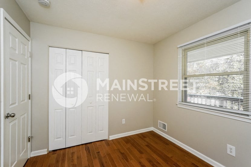 a bedroom with a white door and a window