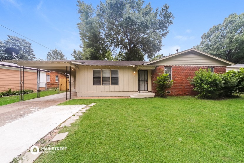 a small brick house with a lawn and a sidewalk