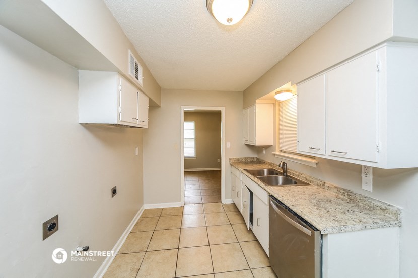 a kitchen with white cabinets and granite counter tops and a sink