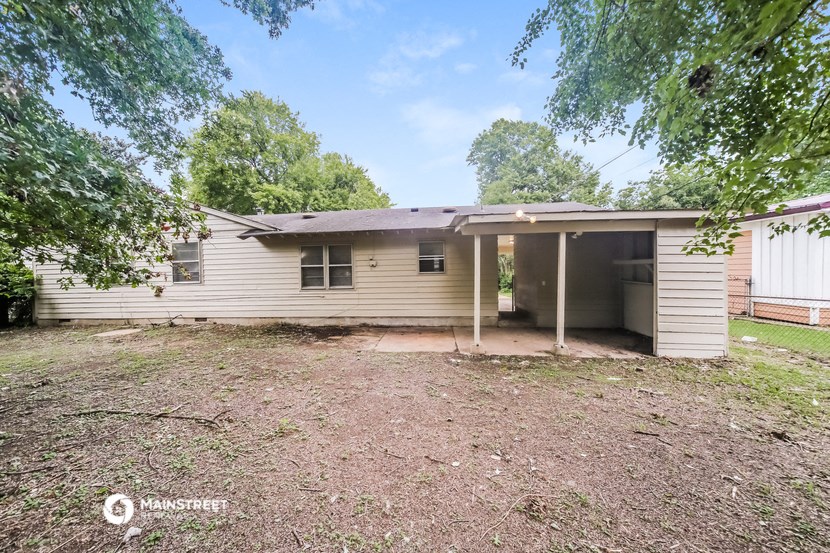 a small white house with a yard and trees