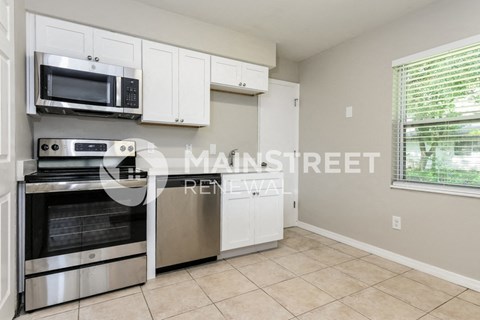 a kitchen with stainless steel appliances and white cabinets