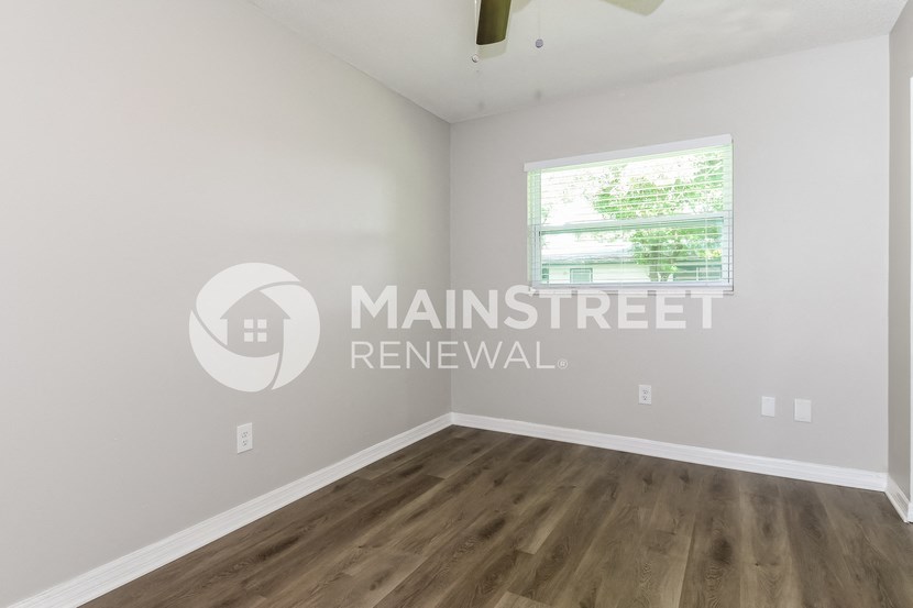 renovated living room with hardwood flooring and a window