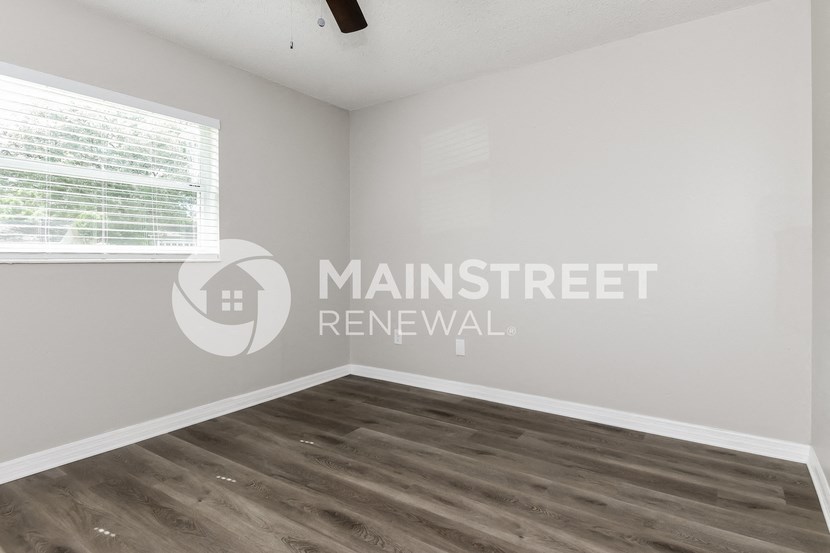 a bedroom with a white wall and a window