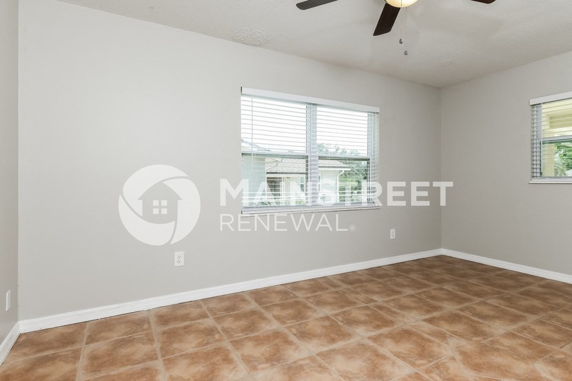 a bedroom with a large window and a tiled floor