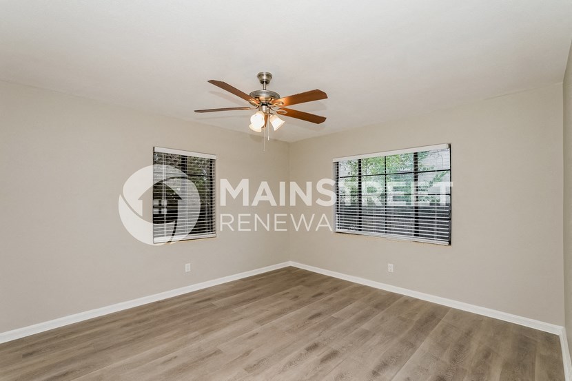 a living room with a ceiling fan and a window