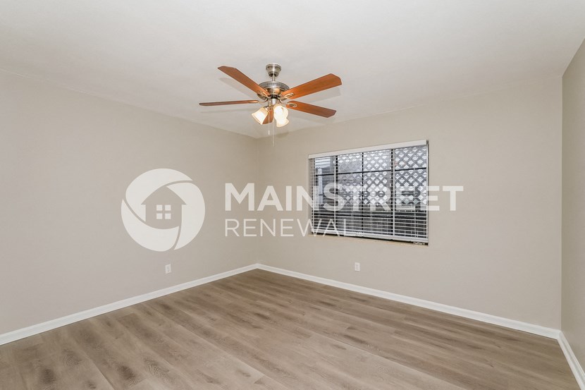 a living room with a ceiling fan and a window
