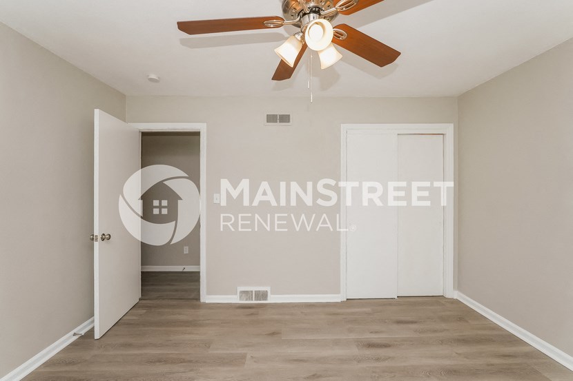 a bedroom apartment with a closet and a ceiling fan