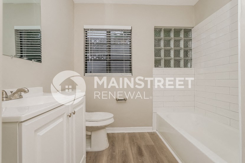 a bathroom with a toilet and a tub and a sink