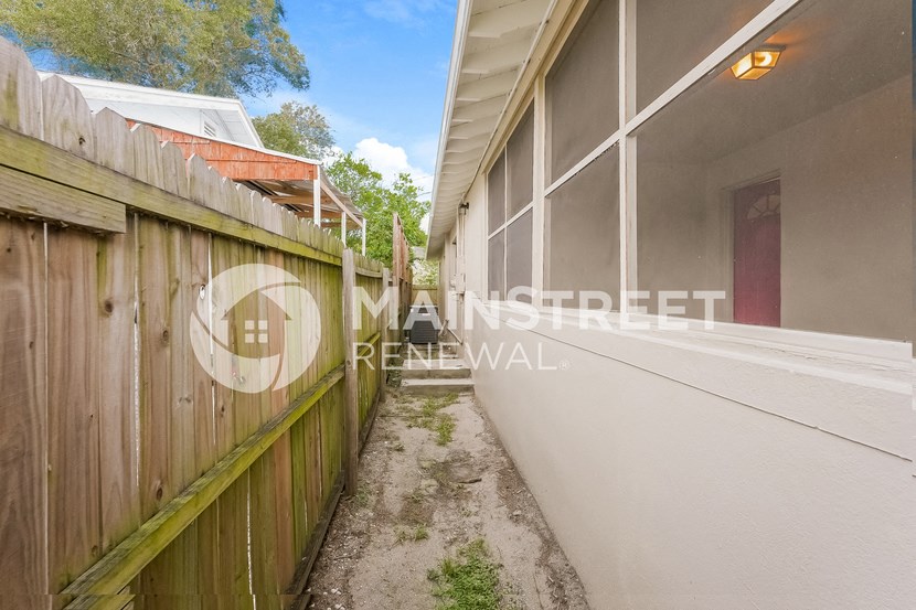a side walk to a house next to a fence