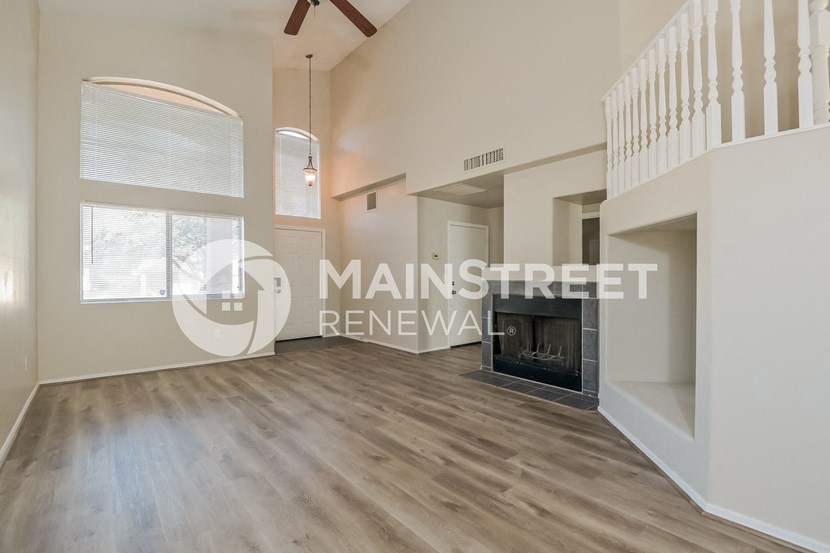 a large living room with a fireplace and a staircase