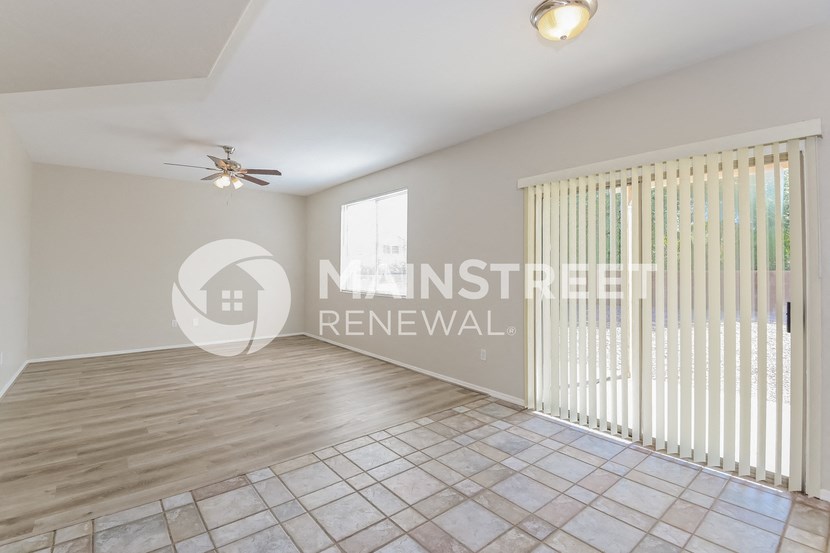 a living room with a large window and a sliding glass door