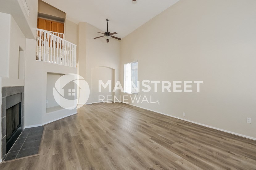 a renovated living room with a fireplace and a staircase
