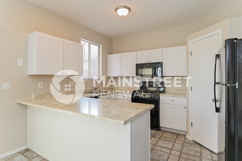 a renovated kitchen with white cabinets and a marble counter top