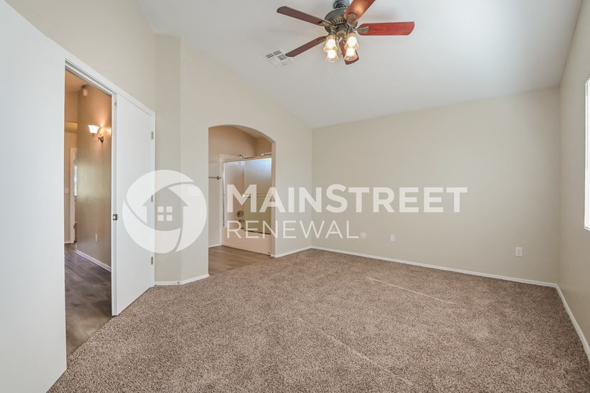 a room with a carpeted floor and a ceiling fan